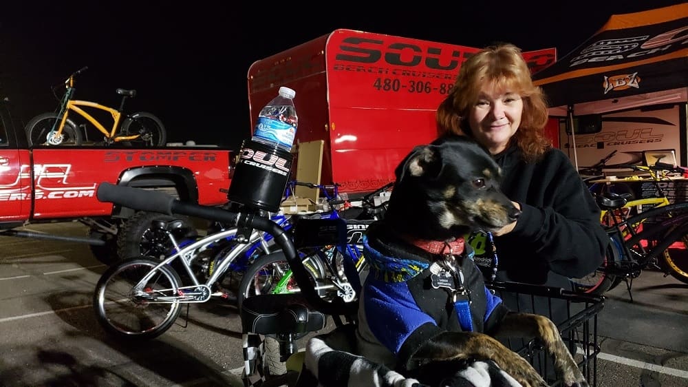 Woman with dog at night bike event.
