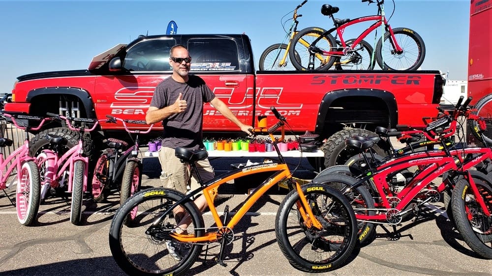 Man posing with bicycles and red truck.