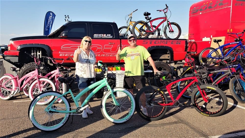 People posing with colorful bicycles and truck.