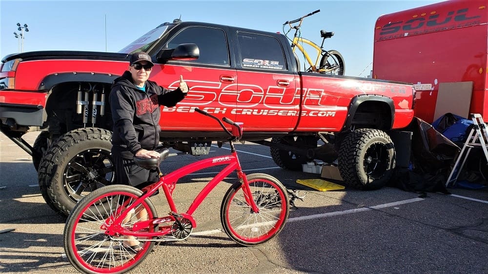 Person with red bike next to truck.