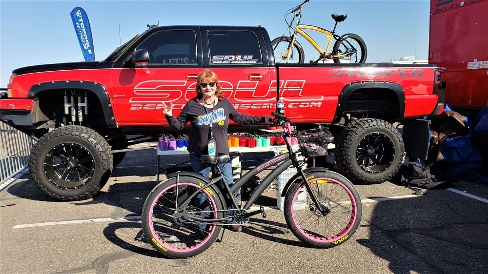 Person with bicycle in front of truck.