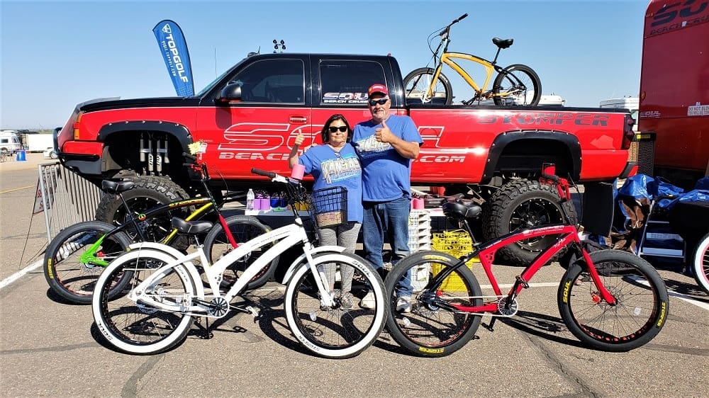 People posing with bikes and a truck.