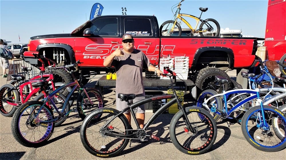 Man with bicycles in front of truck.