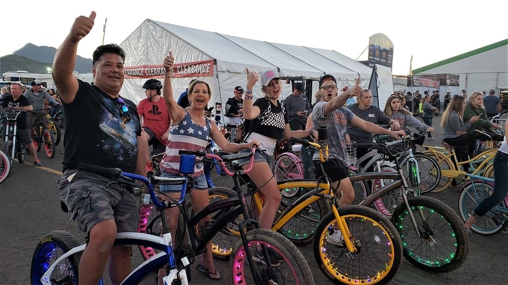 Group enjoying colorful bicycles at outdoor event.