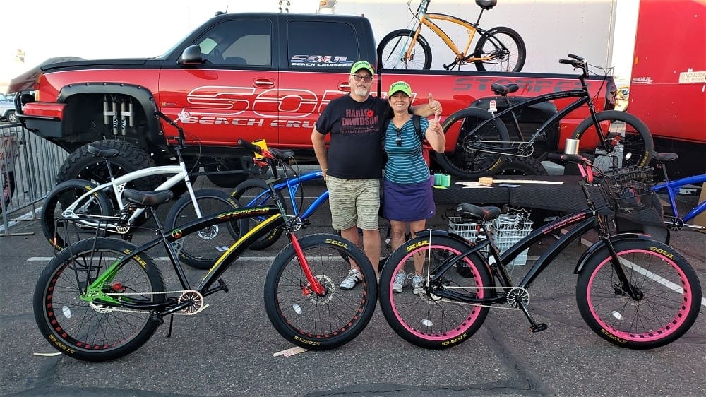Couple posing with custom bicycles and truck.