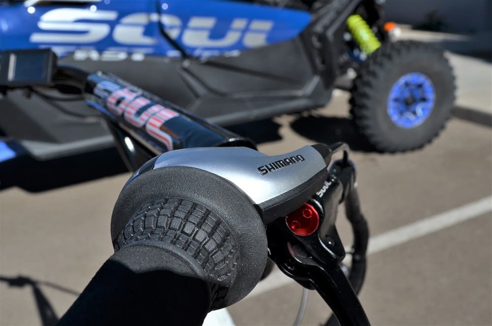 Bicycle handlebar near off-road vehicle.