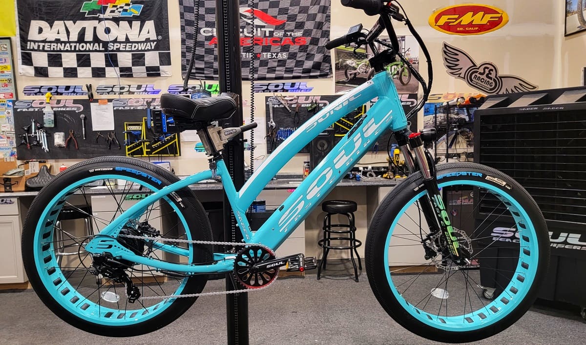 Blue electric bicycle displayed in a workshop.
