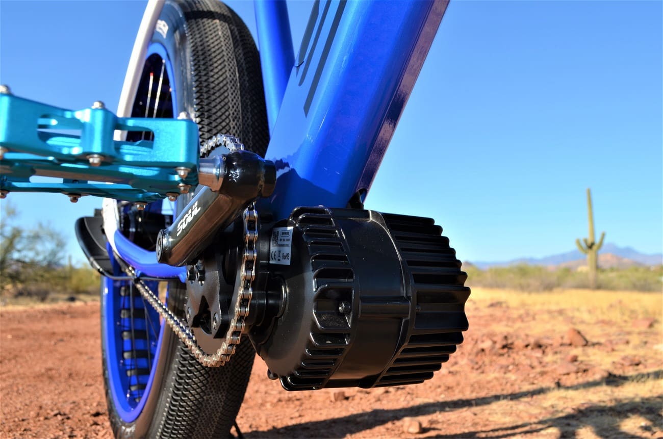 Blue electric bike motor in desert landscape.