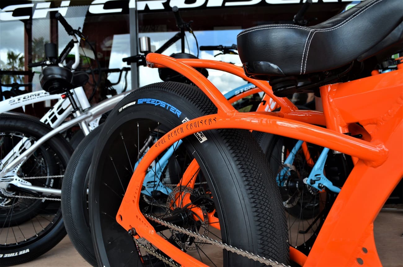 Orange and black bicycles parked in line.