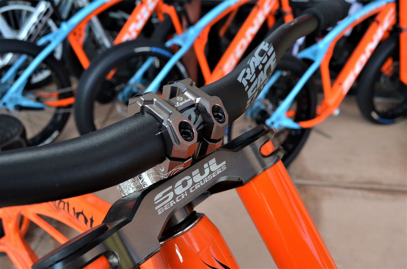 Close-up of orange bicycle handlebars and stem.