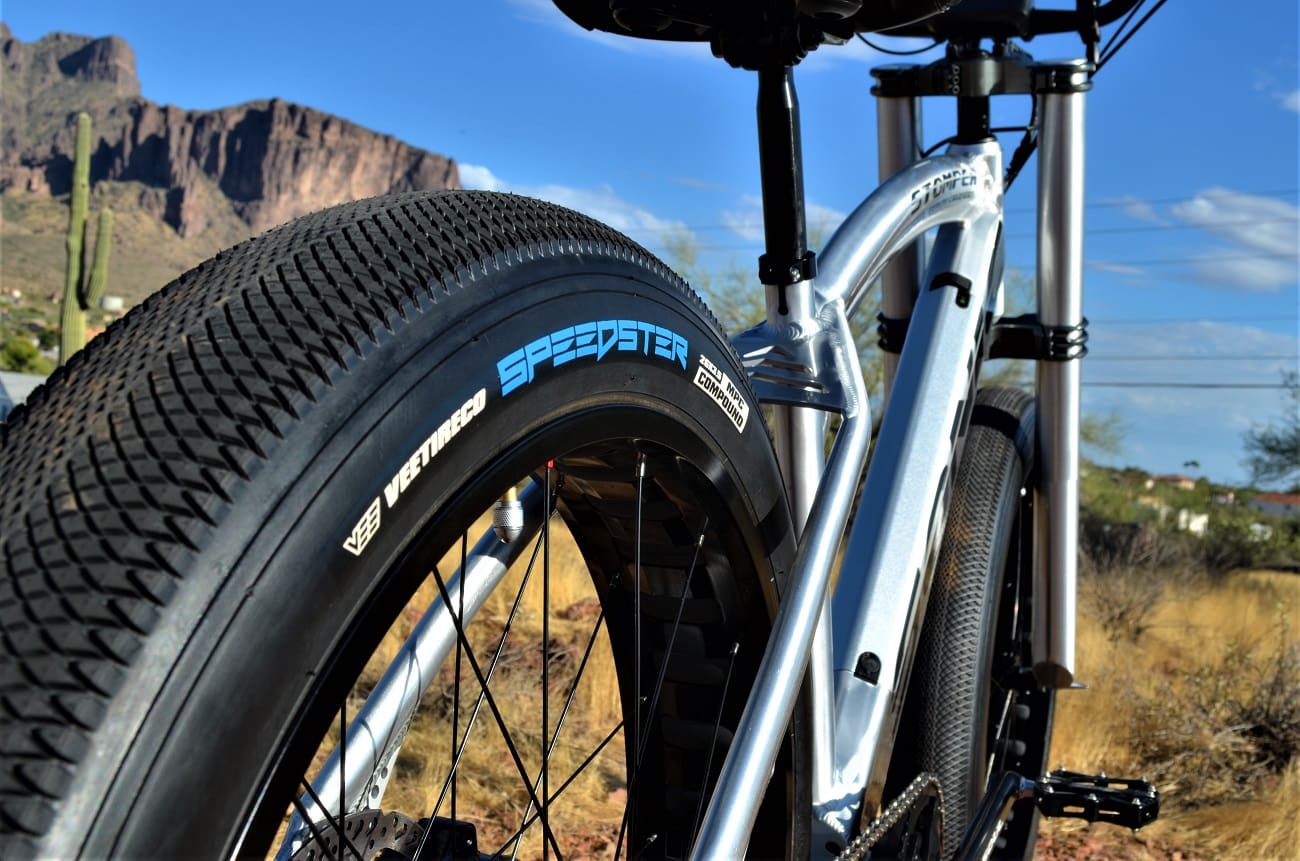 Bicycle tire on desert trail, mountain background.
