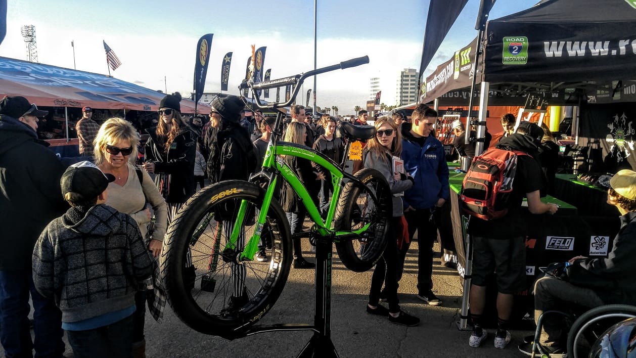 Green bicycle displayed at outdoor bike expo.