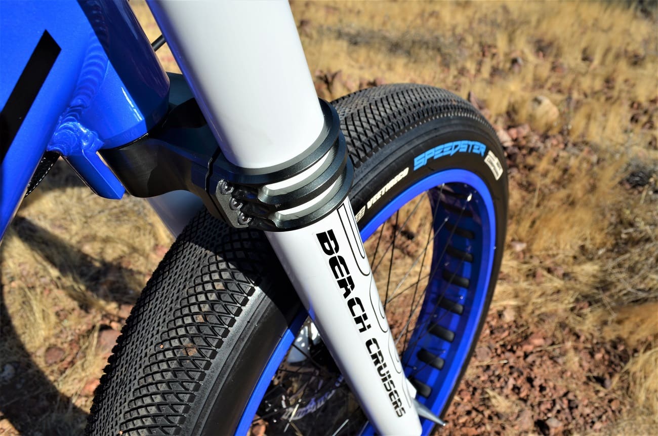 Blue bicycle wheel with thick tire tread.