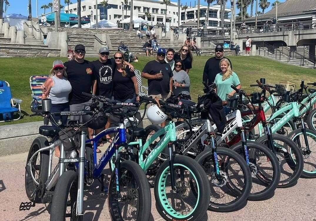 Group posing with bicycles at the beach.