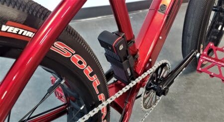 Red bicycle frame with chain and battery.