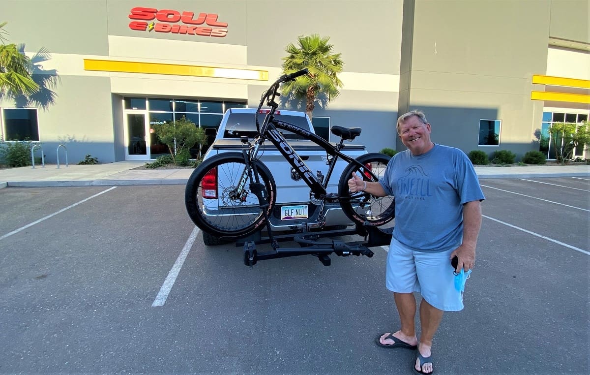 Man with bike on truck rack.