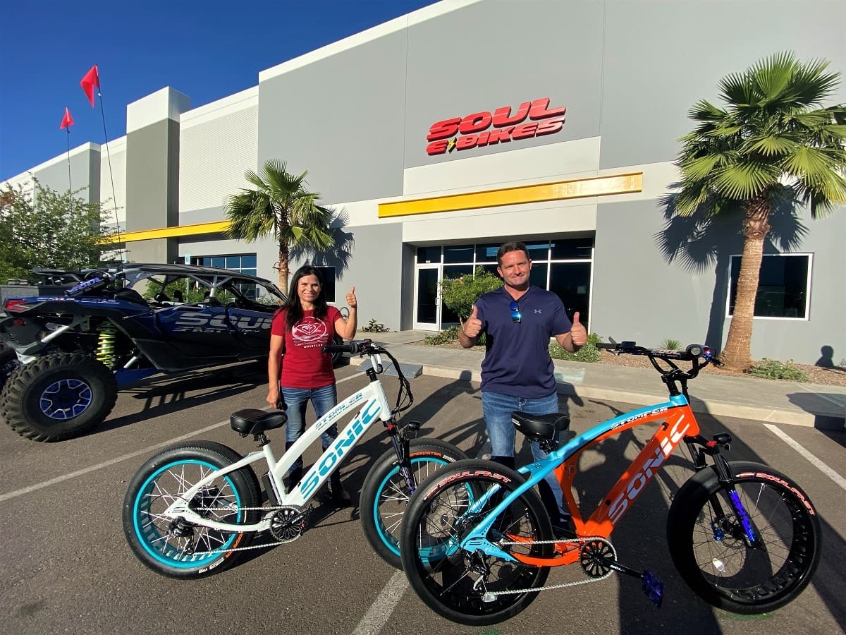 Two people with bikes outside Soul Bikes.