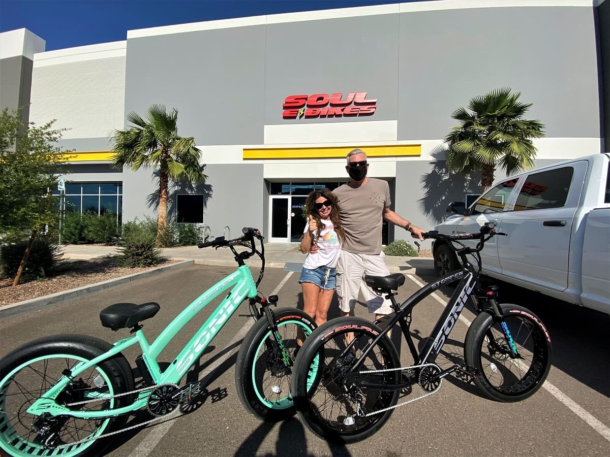 Couple with bicycles outside Soul Bikes store.