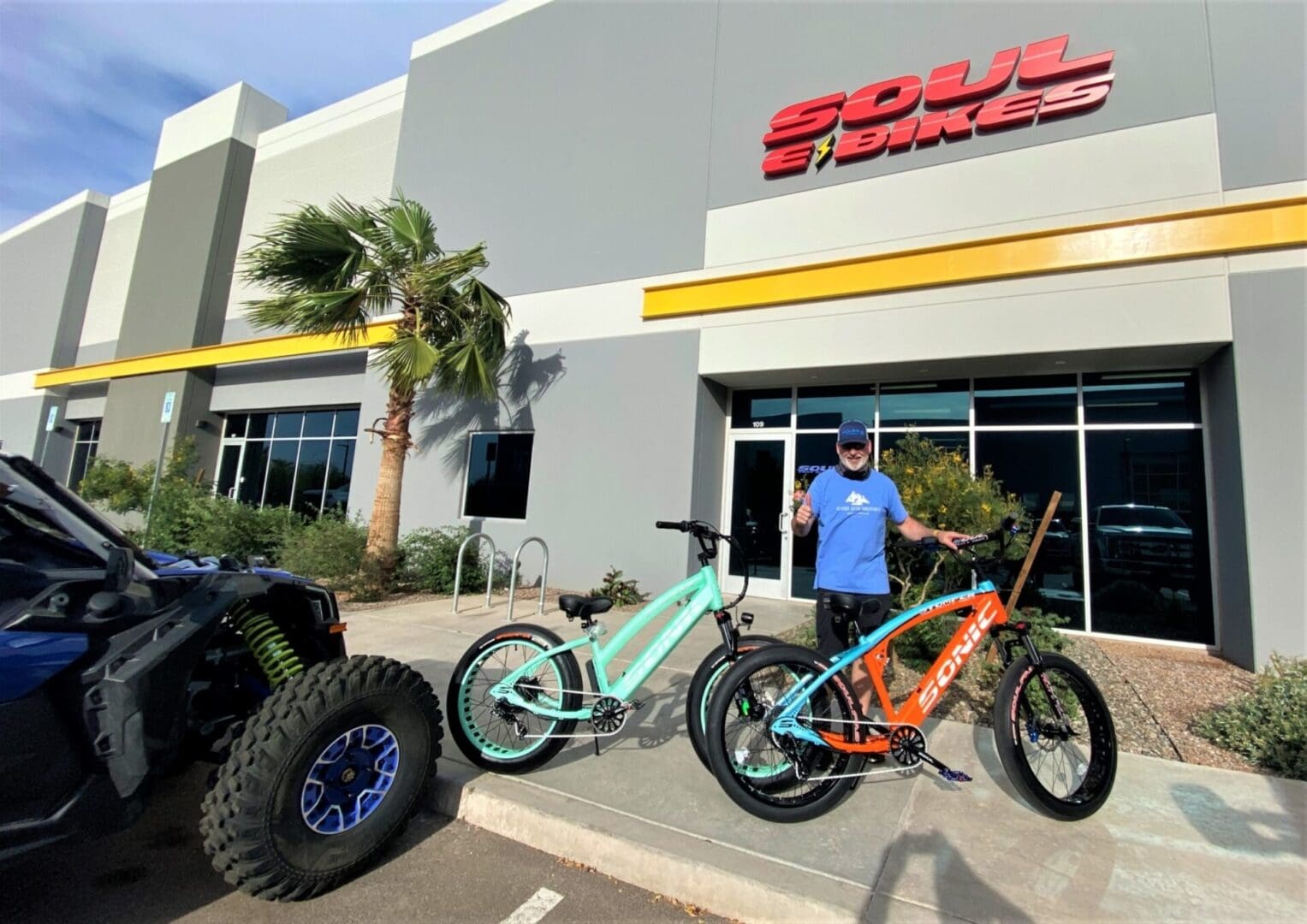 Man with bicycles outside Soul E Bikes store.