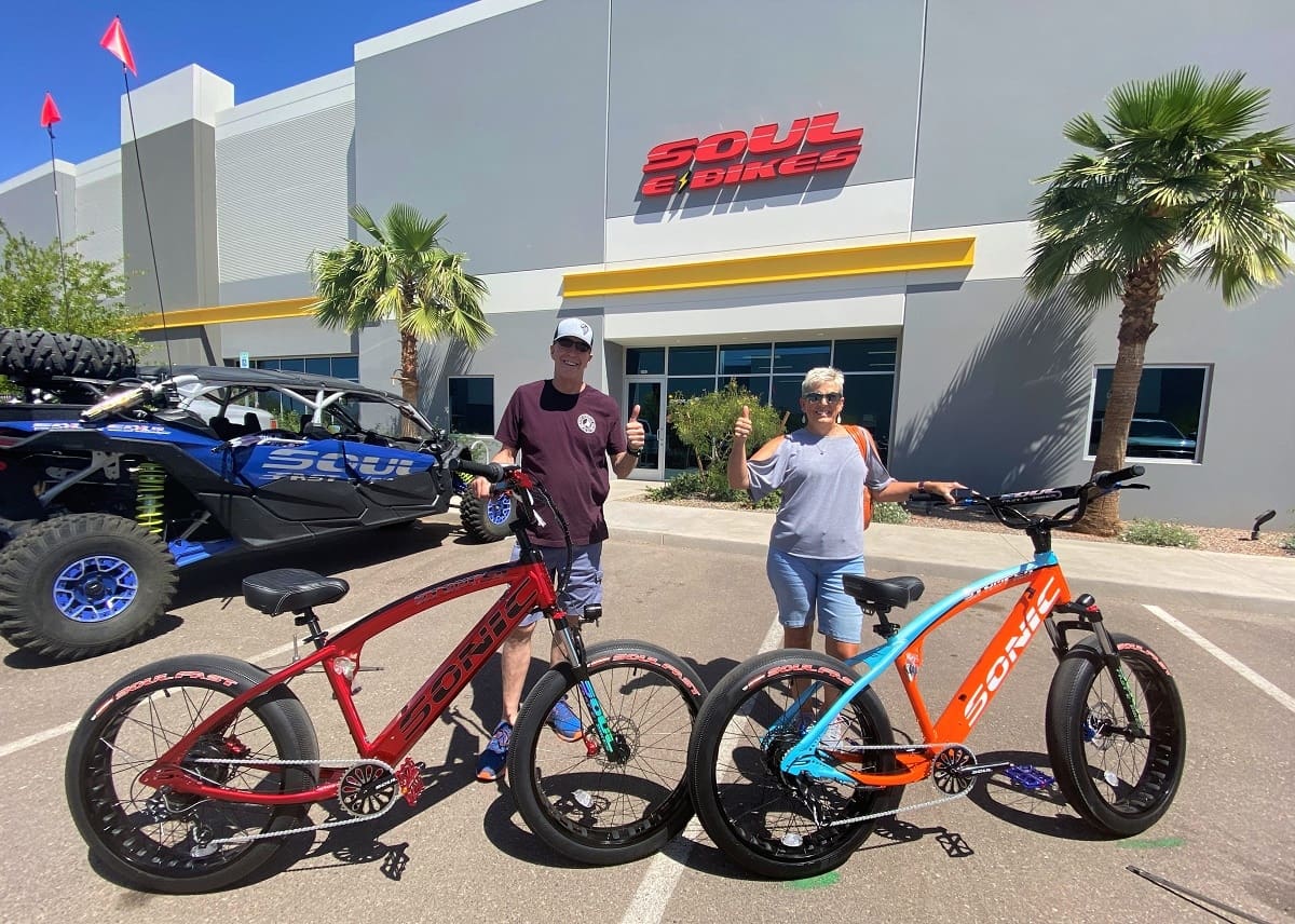Two people with Soul Bikes outside store.