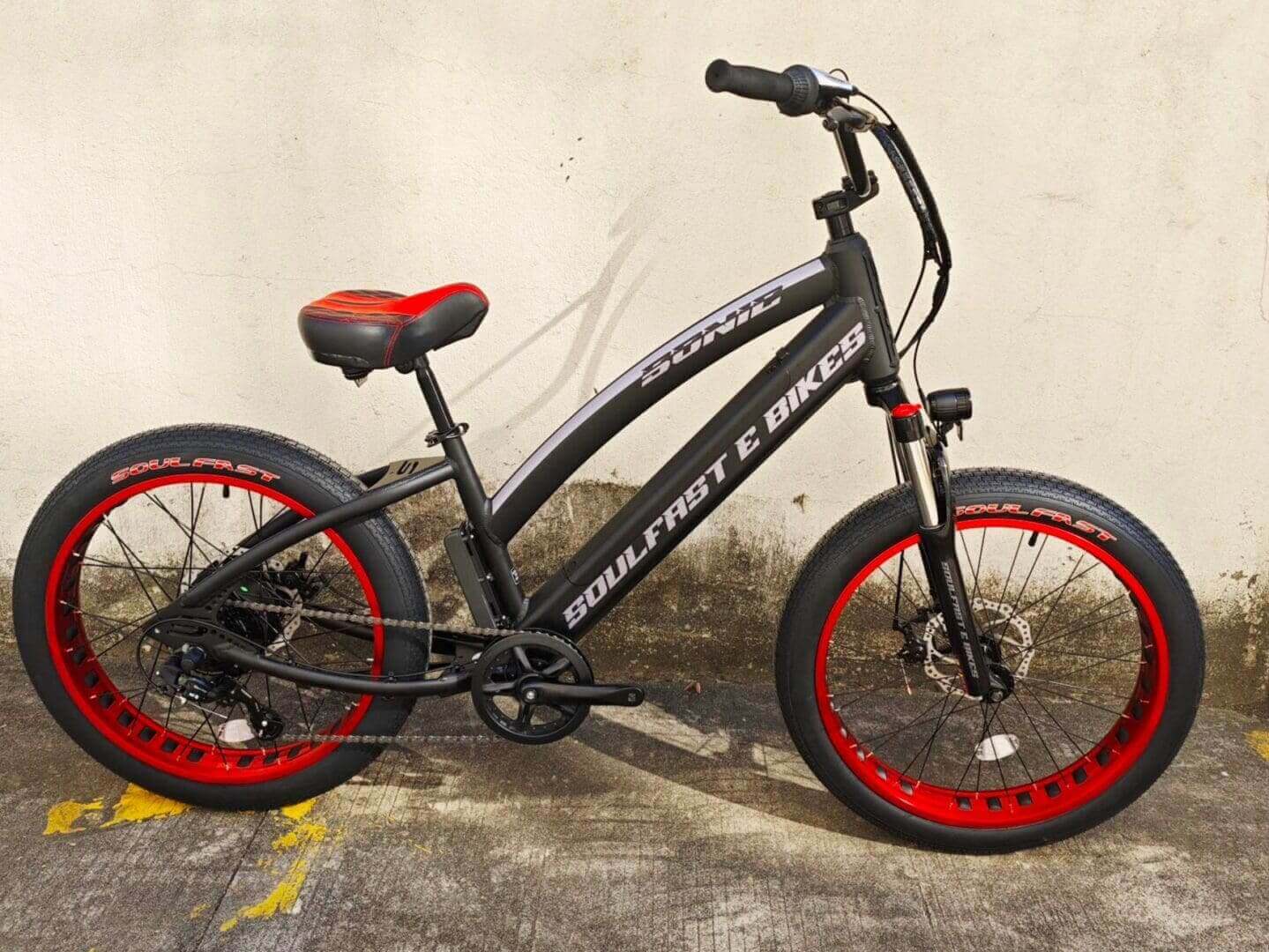 Black and red electric bicycle on pavement.