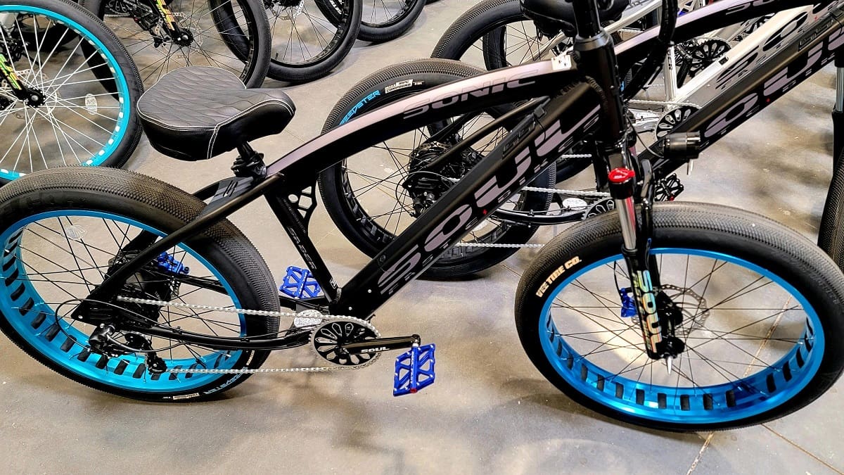 Black bicycle with blue wheel rims displayed.
