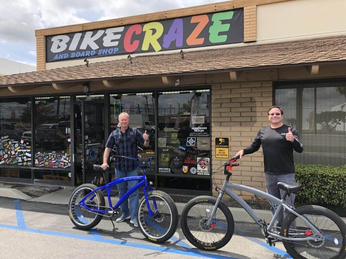 Two people with bikes outside bike shop.