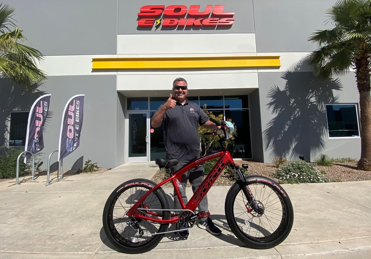 Man posing with red bicycle outside Soul Bikes.