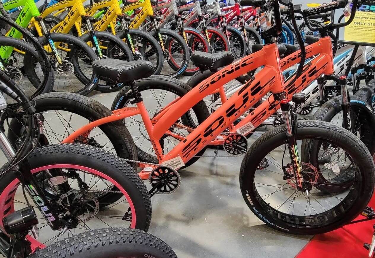 Orange and black bicycles displayed in store.