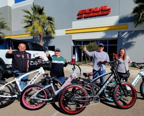 Group of people with bicycles, thumbs up.