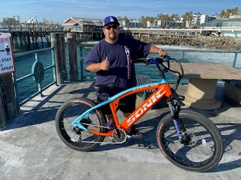 Man with bicycle on a pier.