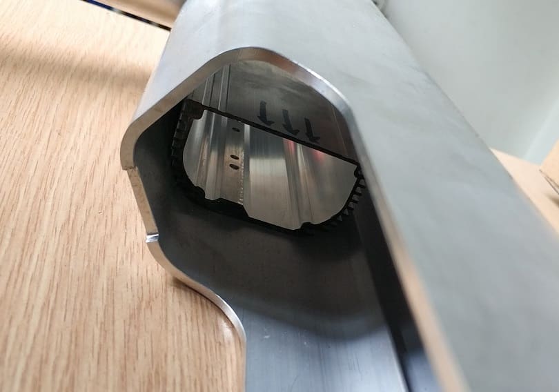 Metallic cross-section on wooden surface.