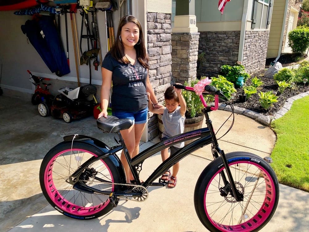 Woman and child with a black bicycle.