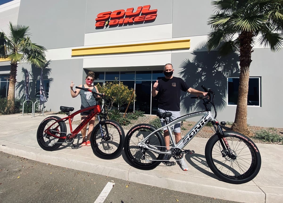 Two people with bikes outside Soul eBikes.