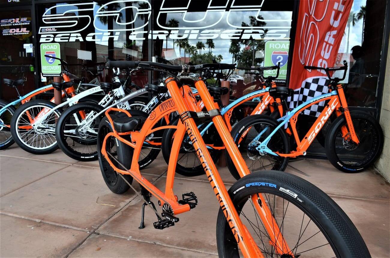 Orange bicycles displayed outside a storefront.