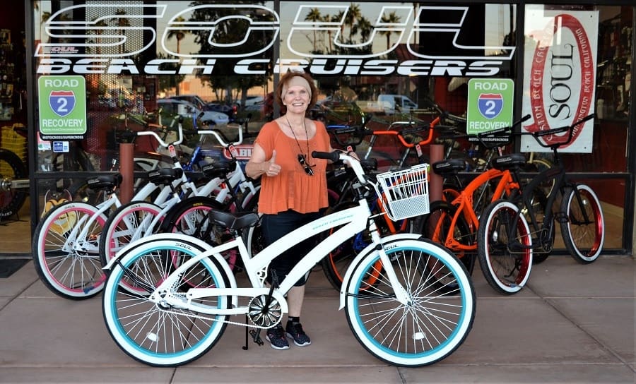 Person with bicycle in front of shop.