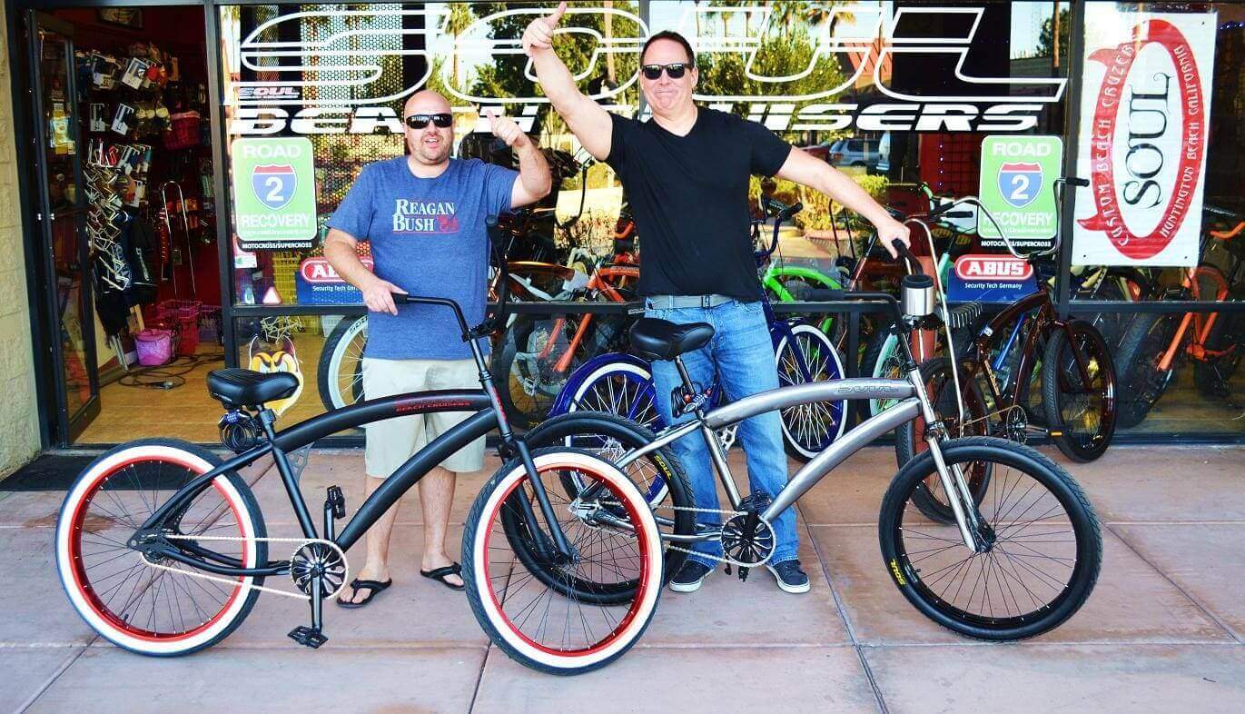Two men with beach cruiser bicycles.