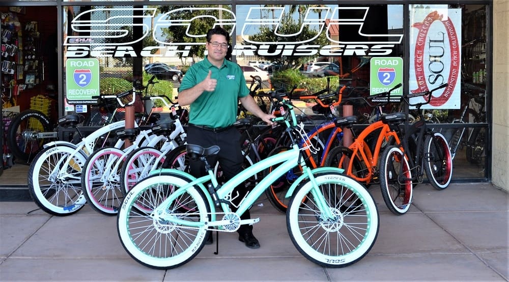 Person with bicycles in front of store.