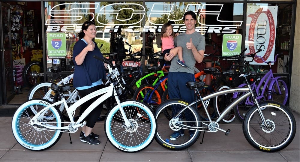 People with bikes outside a bicycle shop.