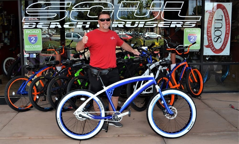 Man with bicycles outside Soul Beach Cruisers.