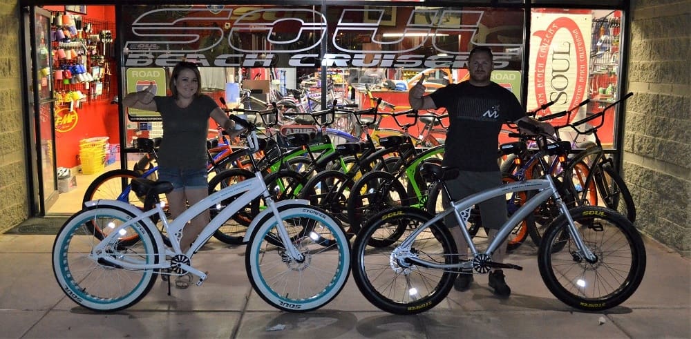 People posing with bikes outside the shop.