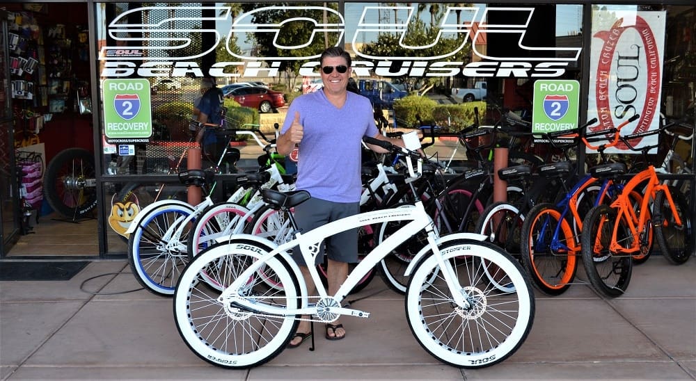 Man with bicycle outside Soul Beach Cruisers.