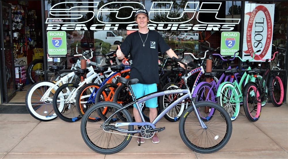 Person with beach cruisers outside a store.
