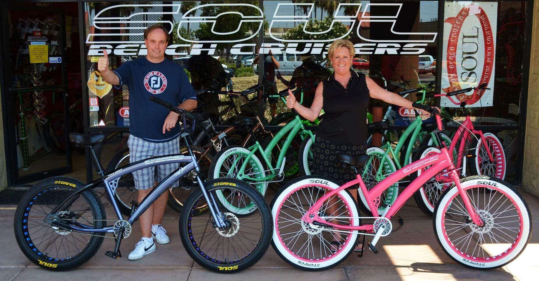 Two people with colorful beach cruiser bikes.