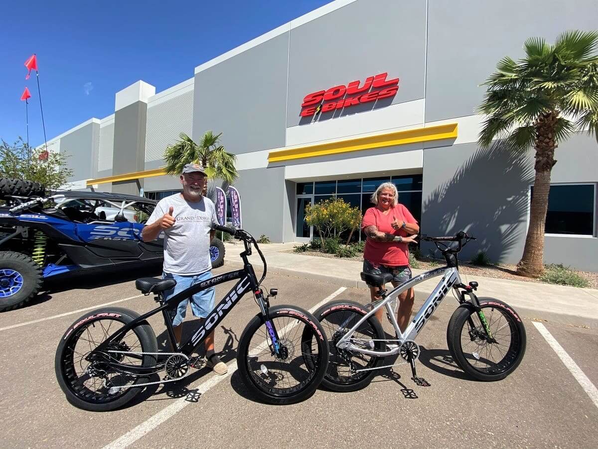 Two people with bicycles outside Soul Bikes.