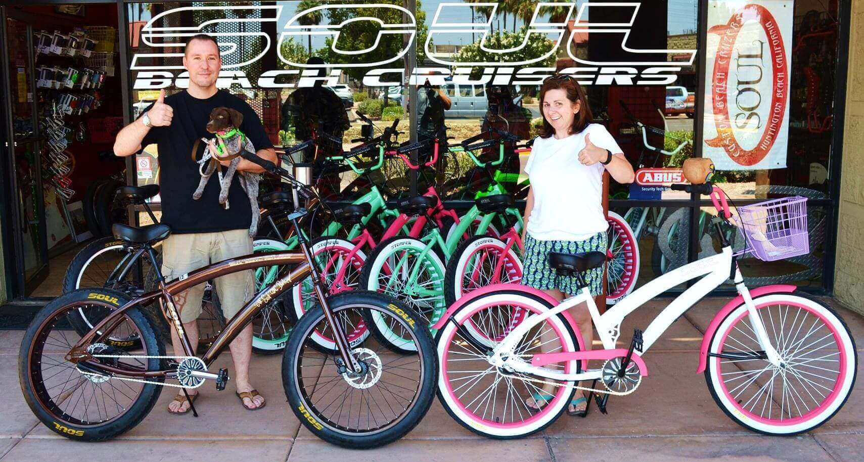 People with bicycles at a bike shop.