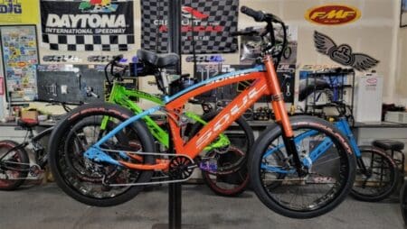 Orange and blue bicycle in a shop.