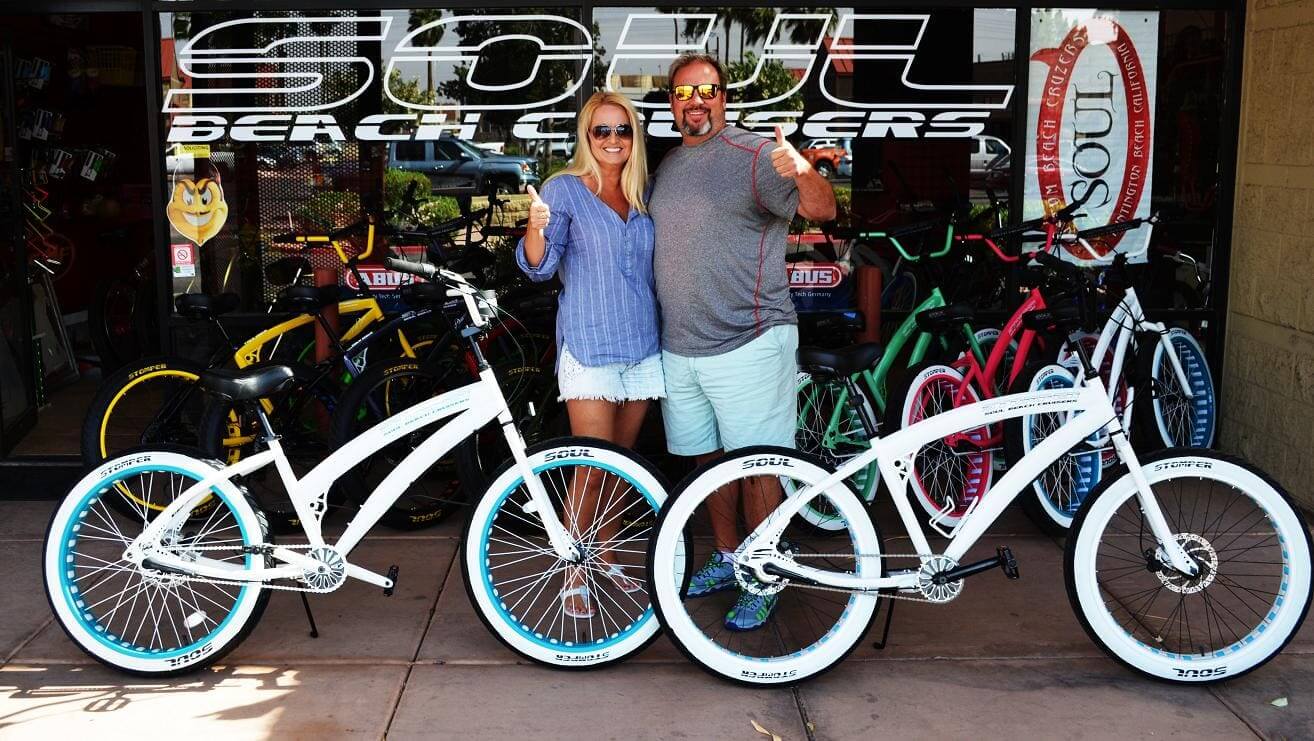 Couple smiling with white beach cruiser bikes.