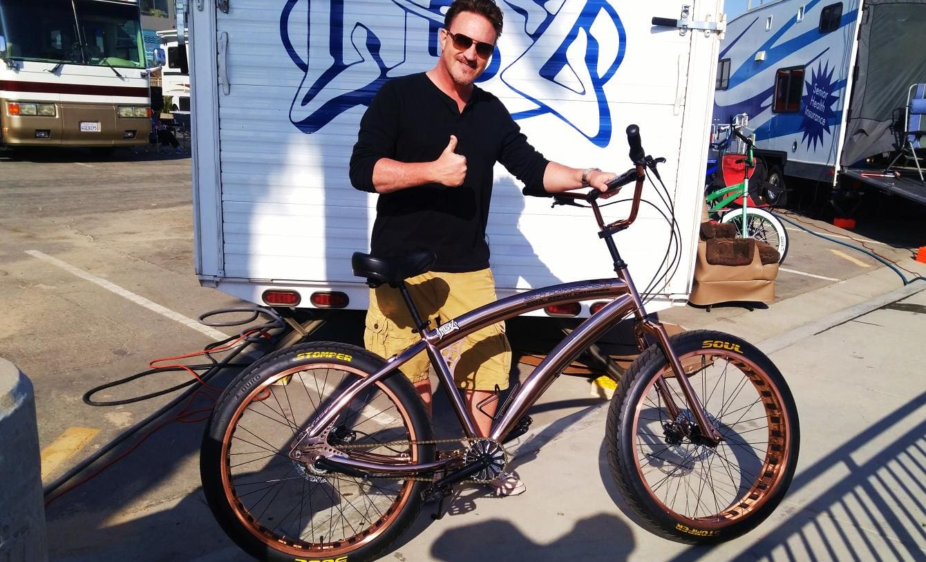 Man giving thumbs up with bicycle.