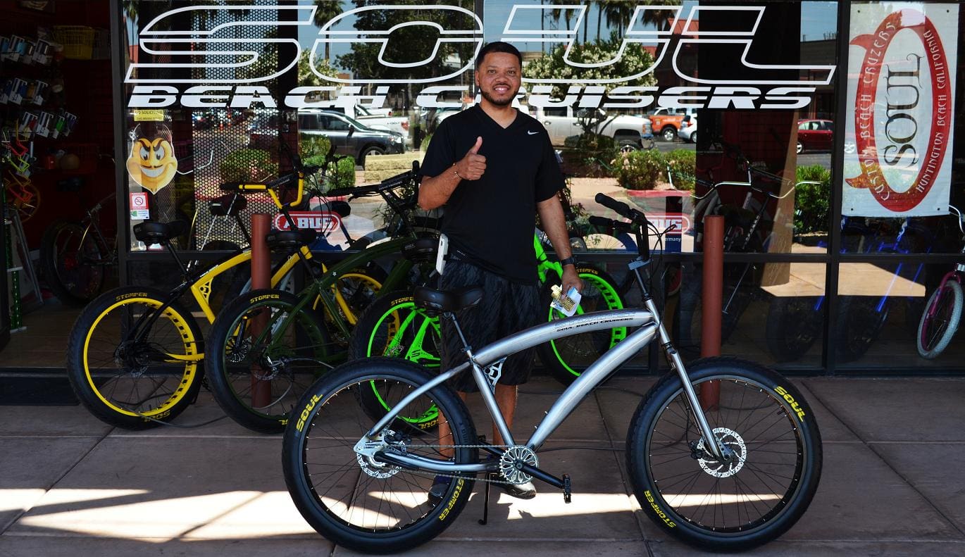Man smiling with bicycles outside Soul shop.
